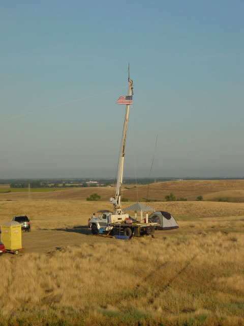 the crane truck with boom raised, antennas at the top